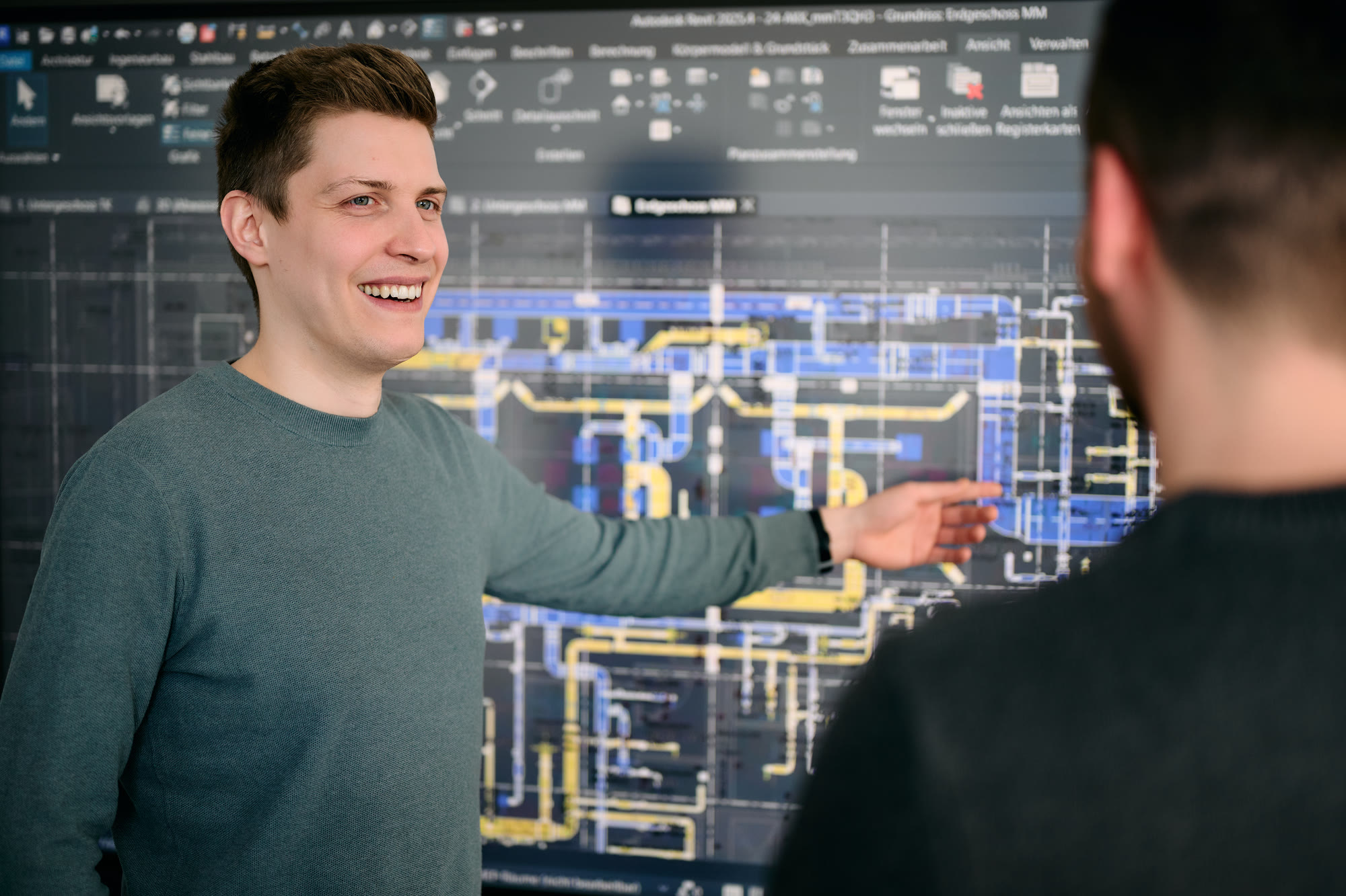Zwei planING-Ingenieure vor einem TGA-Koordinationsmodell in Autodesk Revit